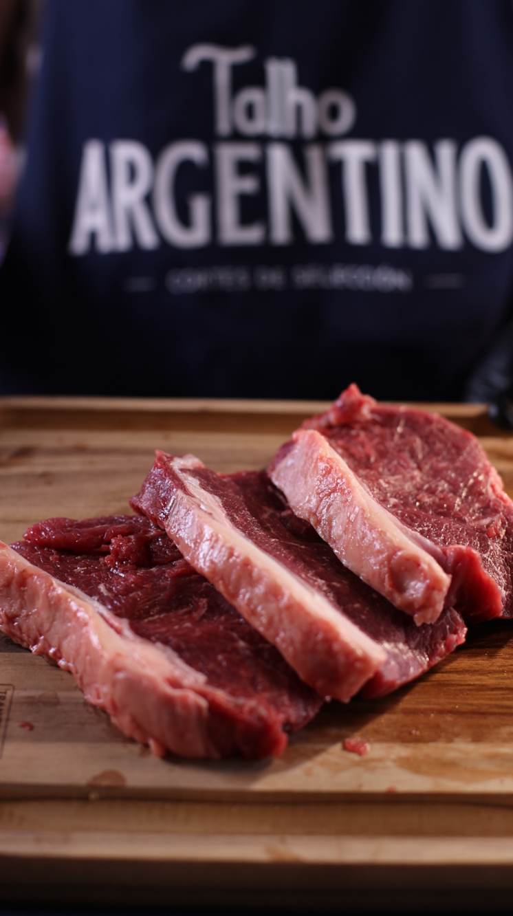 Corte argentino sobre tabla con delantal Talho Argentino de fondo
